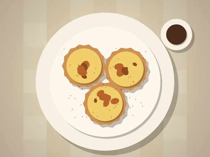 Paper-cut custard tarts with scorched tops on a plate, dusted with cinnamon.
