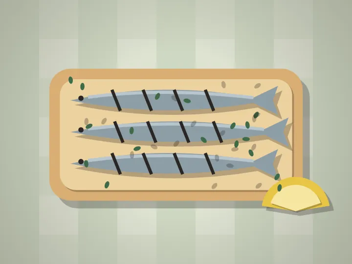 Paper-cut grilled sardines laid over a slice of bread with a lemon wedge.